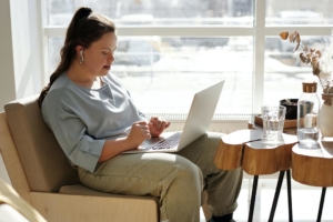 Woman sitting by window with laptop