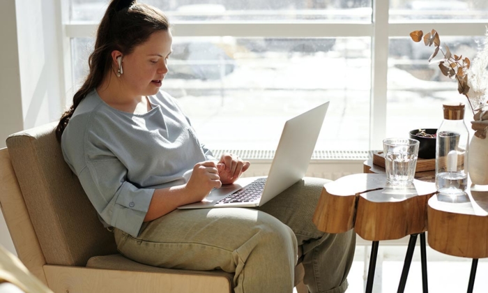 Woman sitting by window with laptop