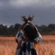 Woman in a field with hands raised